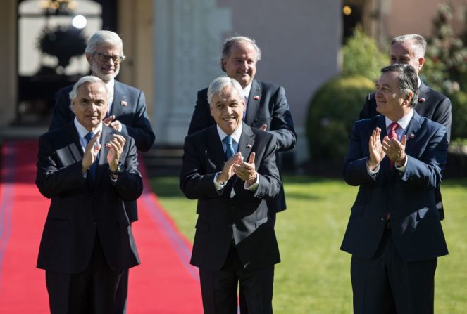 Piñera aplaude mientras posa con su gabinete.