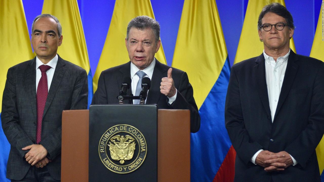 El presidente de Colombia, Juan Manuel Santos (centro), hablando junto al comisionado de paz, Rodrigo Rivera (izquierda) y Gustavo Bell (derecha) en marzo de 2018, cuando ordenó a los negociadores del gobierno que reanuden las conversaciones con el último grupo rebelde activo del país sudamericano, el Ejército de Liberación Nacional (ELN).