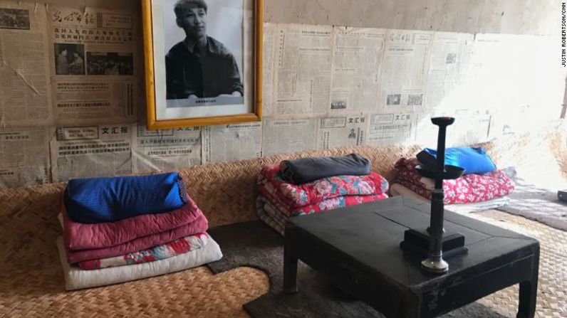 Una foto de un Xi juvenil, así como viejos periódicos, adornan la pared sobre su antigua cama en una "casa cueva".