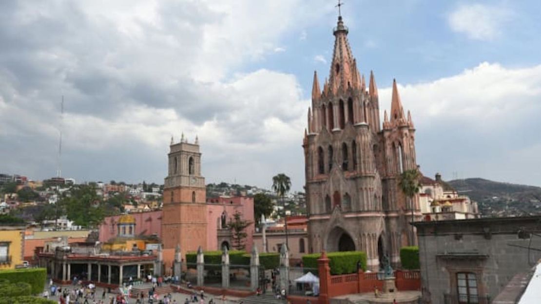 Peatones cruzan la plaza principal en frente de la catedral de San Miguel de Allende.