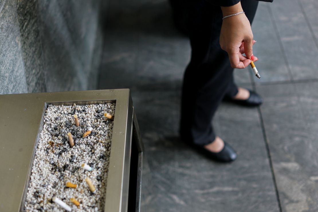 Un cigarrillo con menos nicotina puede salvar millones de vidas en los próximos años, según el estudio que presentamos. En la foto, una mujer fuma tabaco fuera de su oficina.