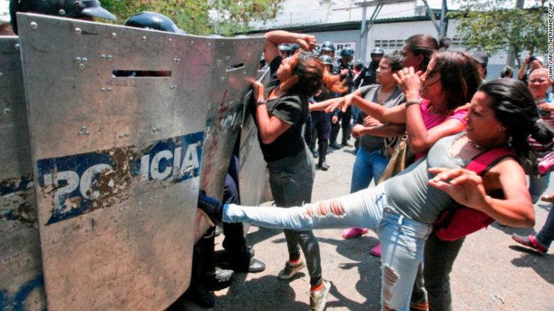 Familiares de los prisioneros pelean contra un grupo de policías mientras esperan información afuera de la estación de policía en Valencia, Venezuela, este miércoles 28n de marzo. El Ministerio Público de Venezuela confirma que al menos 68 personas murieron este miércoles luego de un incendio en un centro de detención de la policía en Valencia, Carabobo.