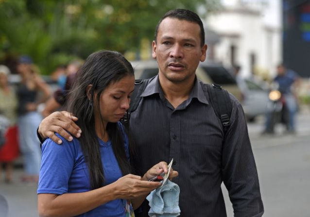 Familiares de prisioneros se abrazan a las puertas de una sede de la policía en Venezuela.