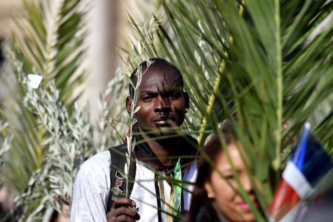 En el Vaticano feligreses católicos sostienen ramos de oliva y palmas durante la misa del Domingo de Ramos en la Plaza de San Pedro el 25 de marzo de 2018.