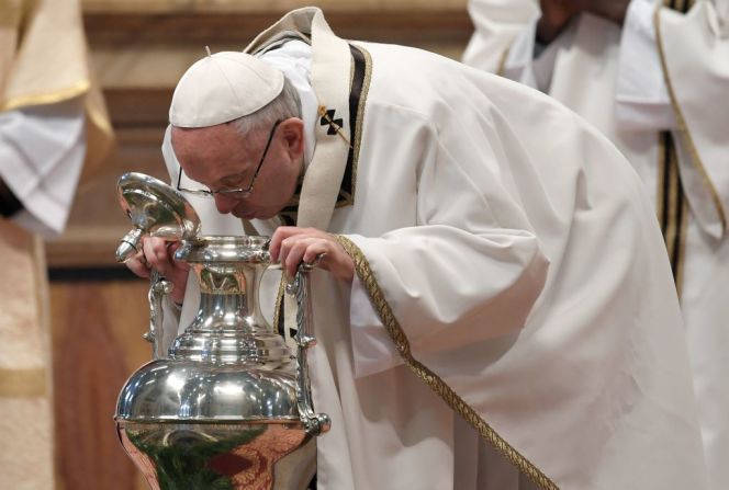 El papa Francisco sopla una ánfora que contiene aceite sagrado en la Santa Misa Crismal el Jueves Santo en la Basílica de San Pedro.