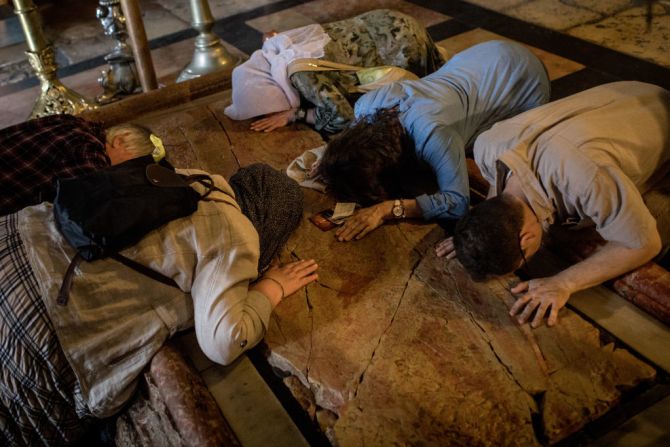 Visitantes besan y tocan la Piedra de la Unción en el Santo Sepulcro en Jerusalén, Israel, el 28 de marzo de 2018. Se dice que allí el cuerpo de Cristo fue ungido antes de su entierro. Miles de turistas y peregrinos llegan cada año a la ciudad santa de Jerusalén para la celebración de la Semana Santa.