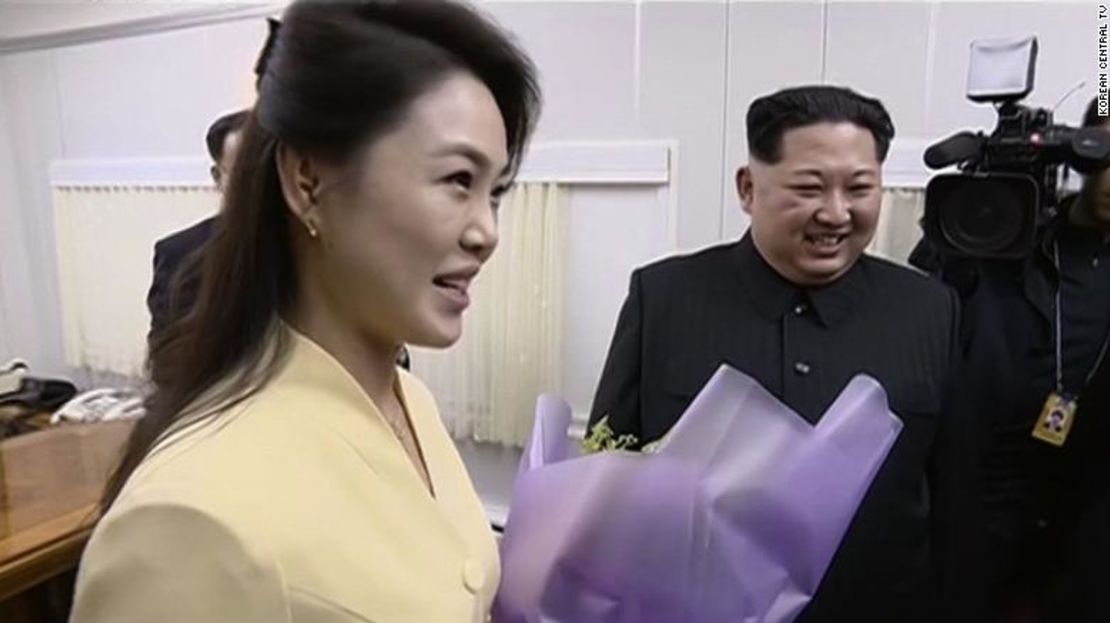 La esposa de Kim, RI Sol Ju, sosteniendo un ramo de flores entregadas a su esposo a su llegada a Dandong.