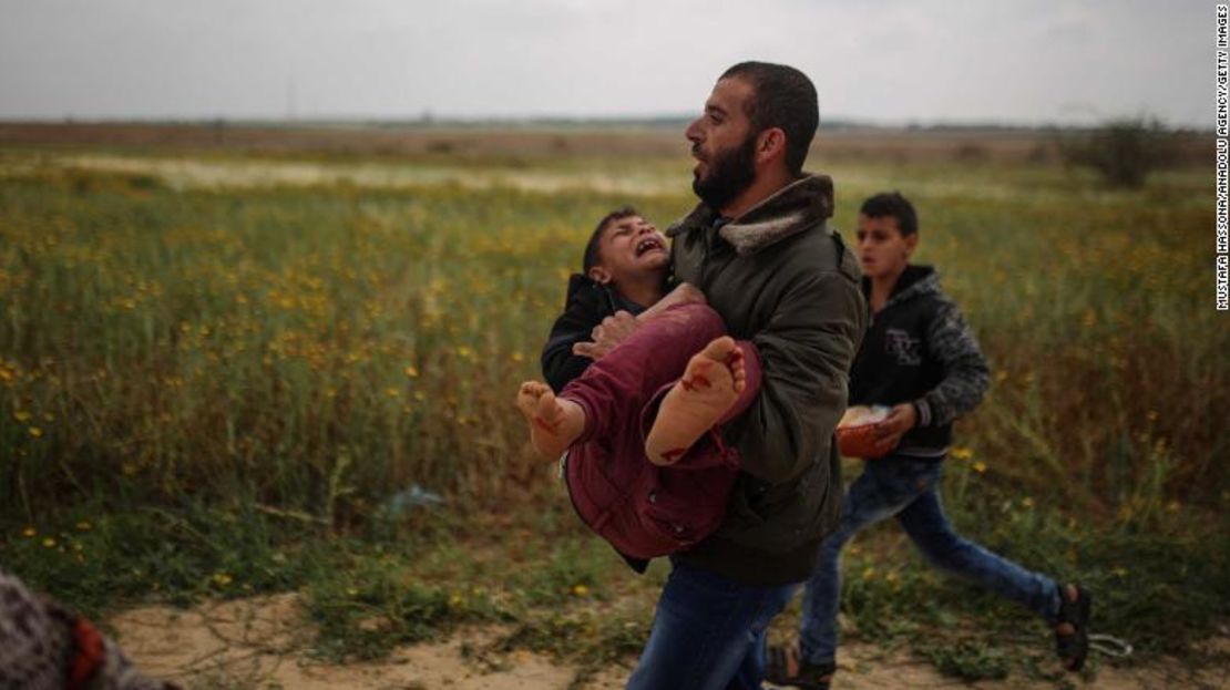 Un adulto palestino lleva a un niño herido después de que las fuerzas israelíes atacaran a los manifestantes palestinos que se reunían en la frontera de Israel, cerca del distrito de Khan Yunis bajo el nombre de "Gran marcha de retorno" en la ciudad de Gaza.