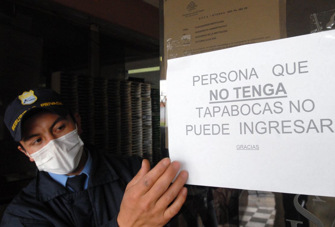 Un miembro de seguridad muestra uno de los carteles que se colgaron en Colombia por la crisis del AH1N1 en 2009. Foto de archivo.