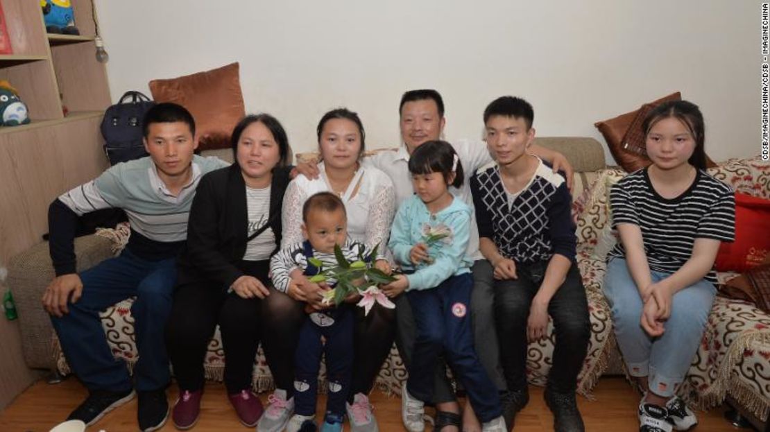 Las familias de Wang Mingqing y su hija desaparecida Kang Ying, segunda a la izquierda, posan para las fotos después de reunirse.