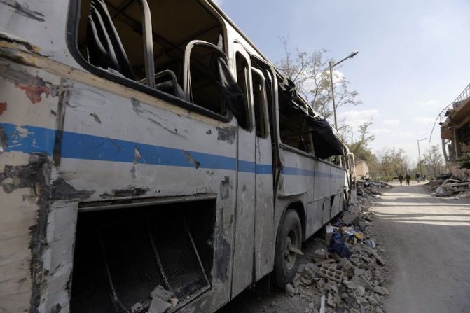 Un autobús destruido cerca del edificio descrito como parte del Centro de Estudios e investigación Científica en el distrito Barzeh, en el norte de Damasco.