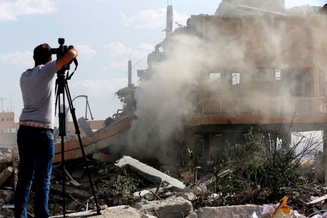 Un periodista captura imágenes del edificio afectado por los bombardeos, de acuerdo con las autoridades sirias.