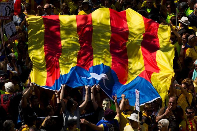 Manifestantes llevan la "estelada", la bandera independentista de Cataluña.