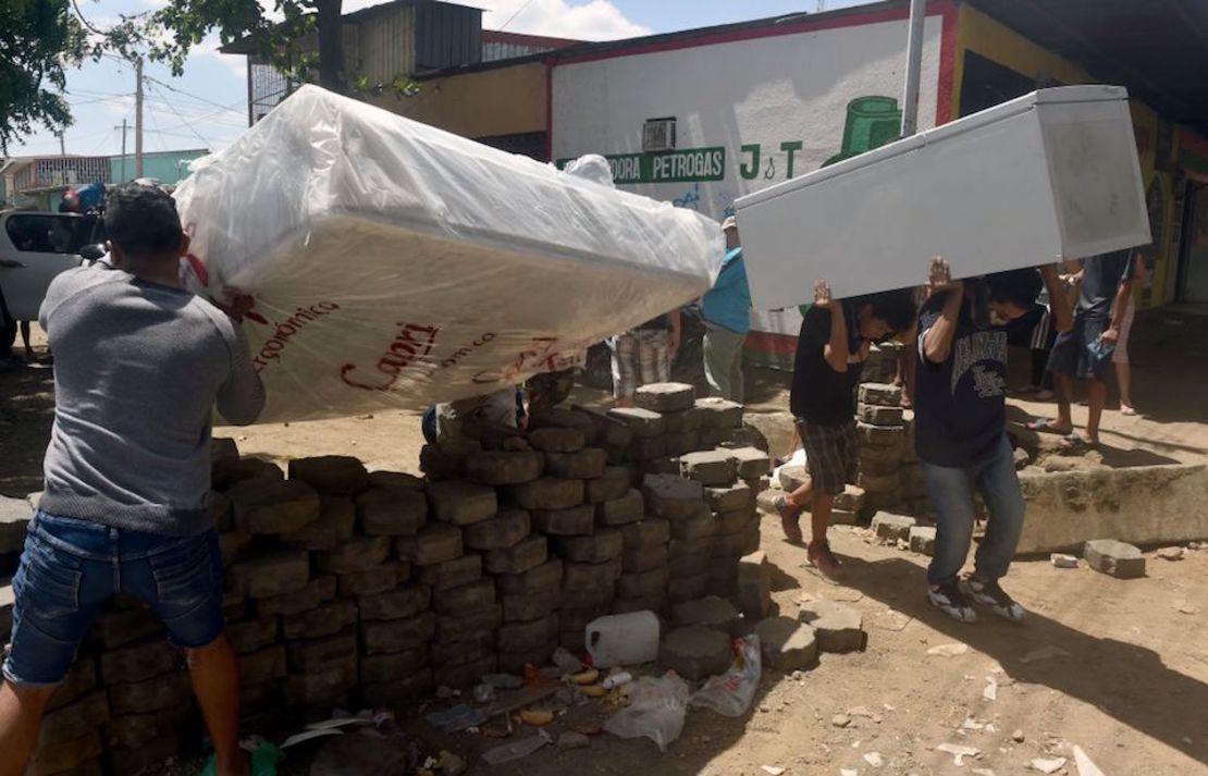 Estudiantes universitarios recuperan objetos que habían sido saqueados más temprano por manifestantes en Managua.