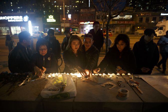 Personas dejan velas y mensajes en el lugar en el que tuvo lugar un atropello masivo que dejó varios muertos en Toronto (Canadá) durante la noche del 23 de abril de 2018.