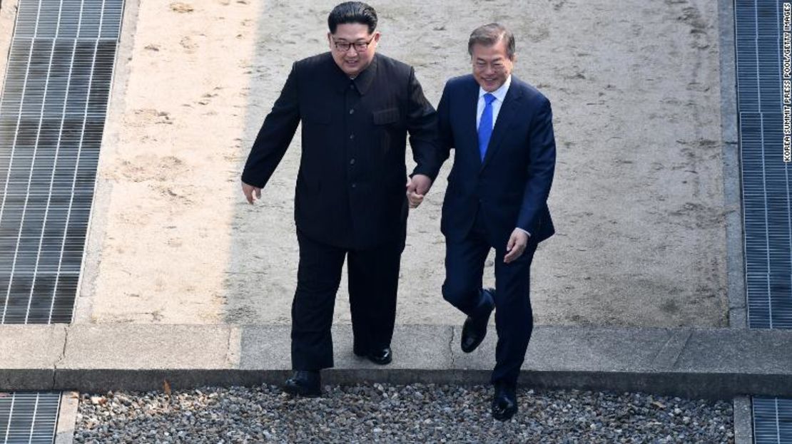 El líder norcoreano Kim Jong Un (a la izquierda) y el presidente surcoreano Moon Jae-in se dan la mano para cruzar la Línea de Demarcación Militar en la zona desmilitarizada el 27 de abril de 2018.