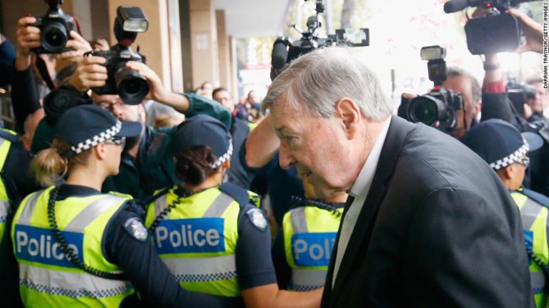 El cardenal George Pell camina a través de cordón de policías en el Tribunal de Magistrados de Melbourne, el 1 de mayo de 2018. El prelado se enfrenta a cargos por abuso sexual histórico.