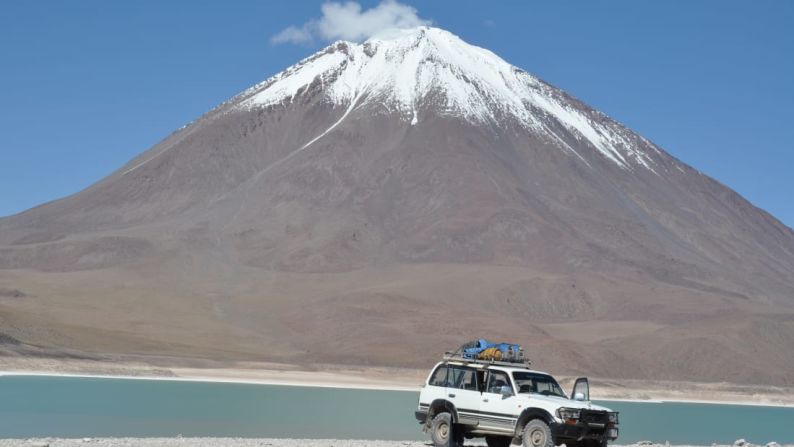 La superficie color aguamarina de Laguna Verde en Bolivia captura brillantemente el volcán cónico de Licancabur reflejado en la superficie. Crédito: Jacquie Whitt