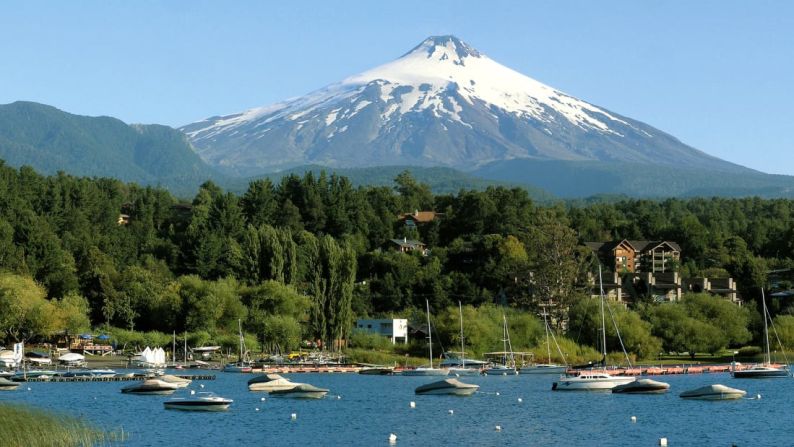 Este volcán (Villarrica, Chile) también tiene un lago de montaña y un pintoresco pueblo en la base. La vista es impresionante, ya sea desde la parte inferior o mirando hacia abajo en su burbujeante lago de lava. Cortesía: Turismo Chile