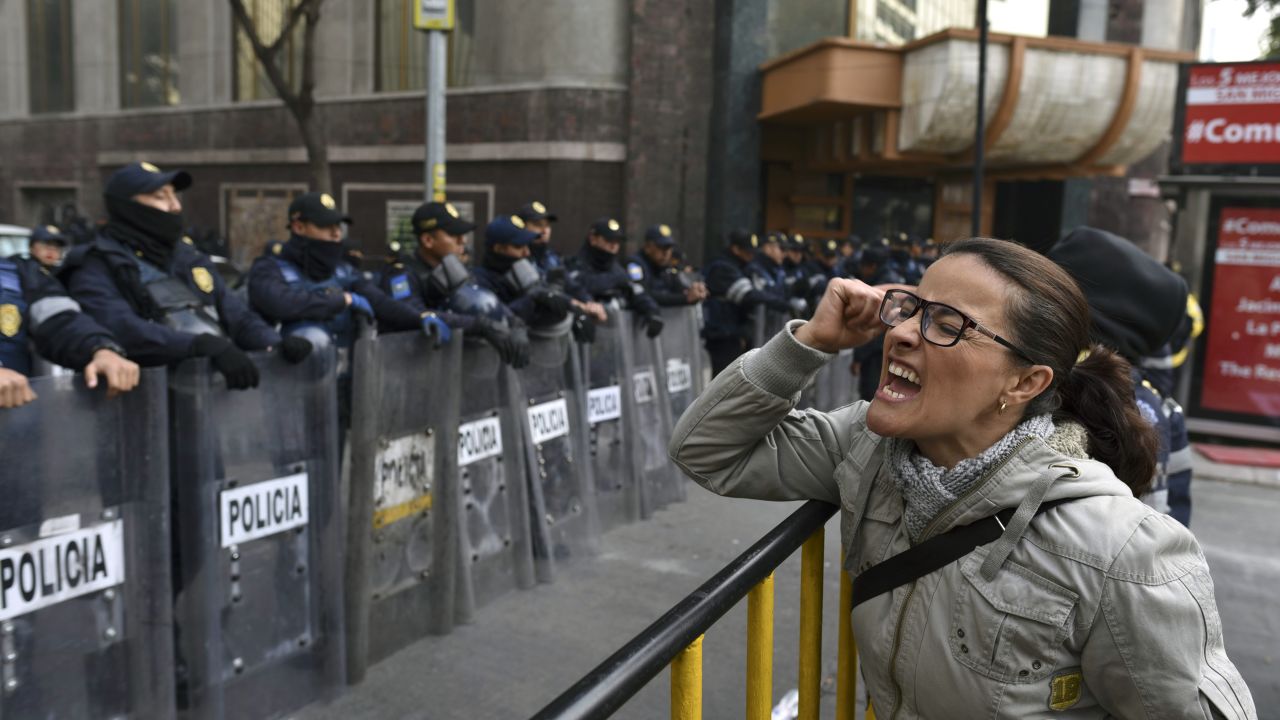 TOPSHOT - A demonstrator shouts slogans in front of the Senate building during a protest against the potential approval of an Internal Security Law which would allow the army to act as police, in Mexico City, on December 14, 2017. 
Mexican deputies approved a new security law which provides a legal framework for military deployment, the controversial initiative is being discussed in the Senate. / AFP PHOTO / YURI CORTEZ