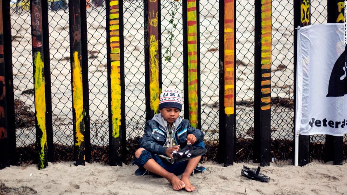 Un niño centroamericano que viajó en la caravana de inmigrantes espera en la frontera junto a Estados Unidos.