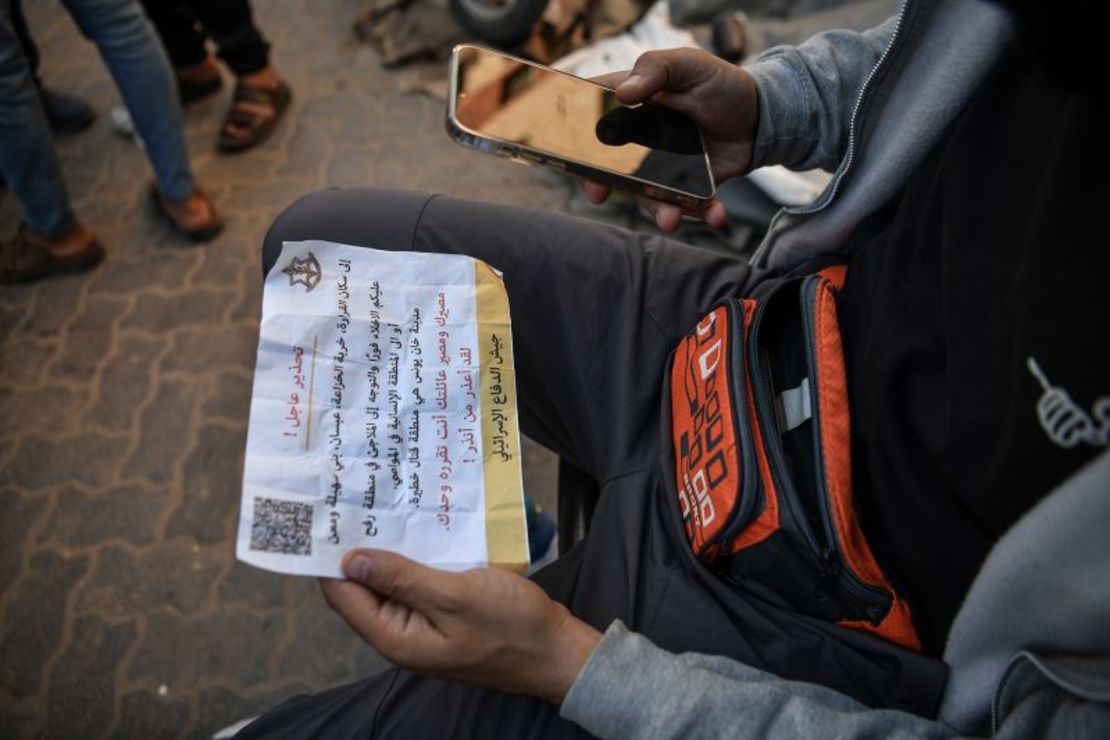 Un palestino sostiene un folleto lanzado por las fuerzas israelíes, instando a los residentes a abandonar las regiones de Al-Qarara, Khuza'a, Bani Suheila y Maan de la ciudad de Khan Younis, en Gaza, el sábado. Abed Zagout/Anadolu/Getty Images