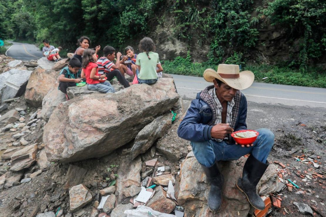 Familias desplazadas de la rivera del río Cauca comen cerca a una vía cerca del municipio de Ituango, en Antioquia, el 13 de mayo de 2018.