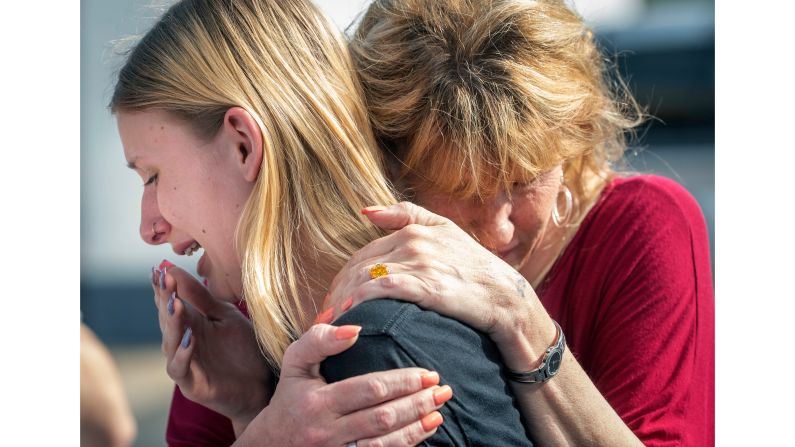 Estudiante abraza a su madre a las afueras de la escuela.