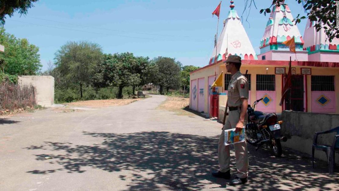 Un policía vigila la entrada principal a la aldea de Rasana. La policía local aumentó su presencia en la aldea tras la violación y el asesinato de la niña musulmana.