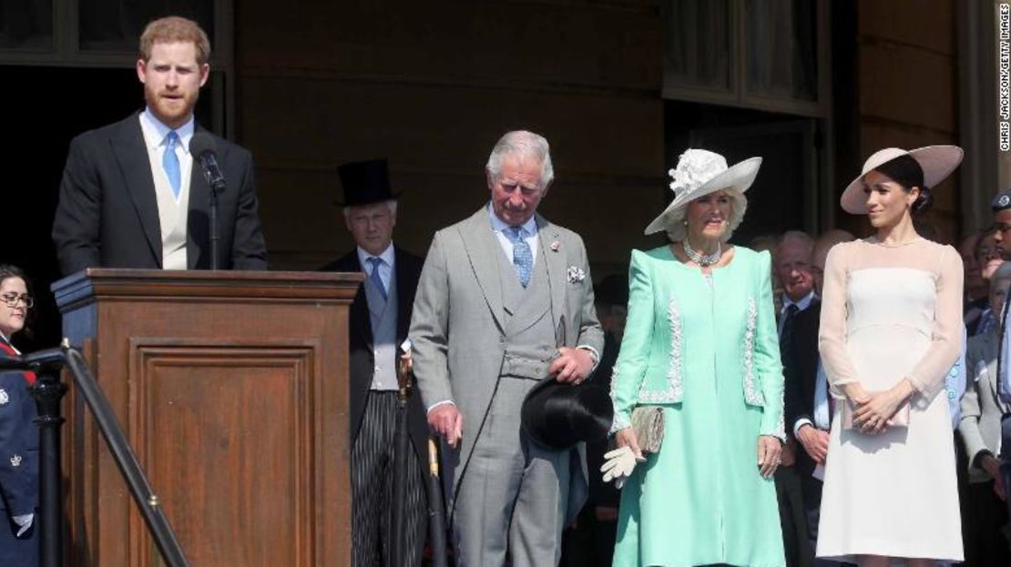 Enrique, en la foto a la izquierda, da un discurso junto al príncipe Carlos, su esposa Camilla y Meghan, en la fiesta del martes.