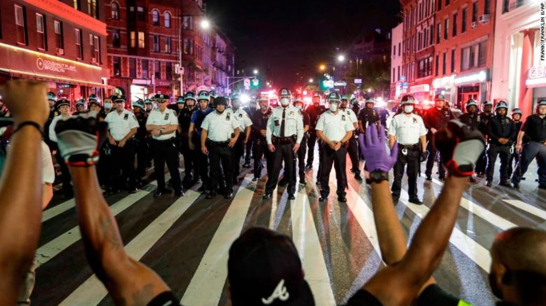 Manifestantes se arrodillan frente a agentes de policía en Nueva York.