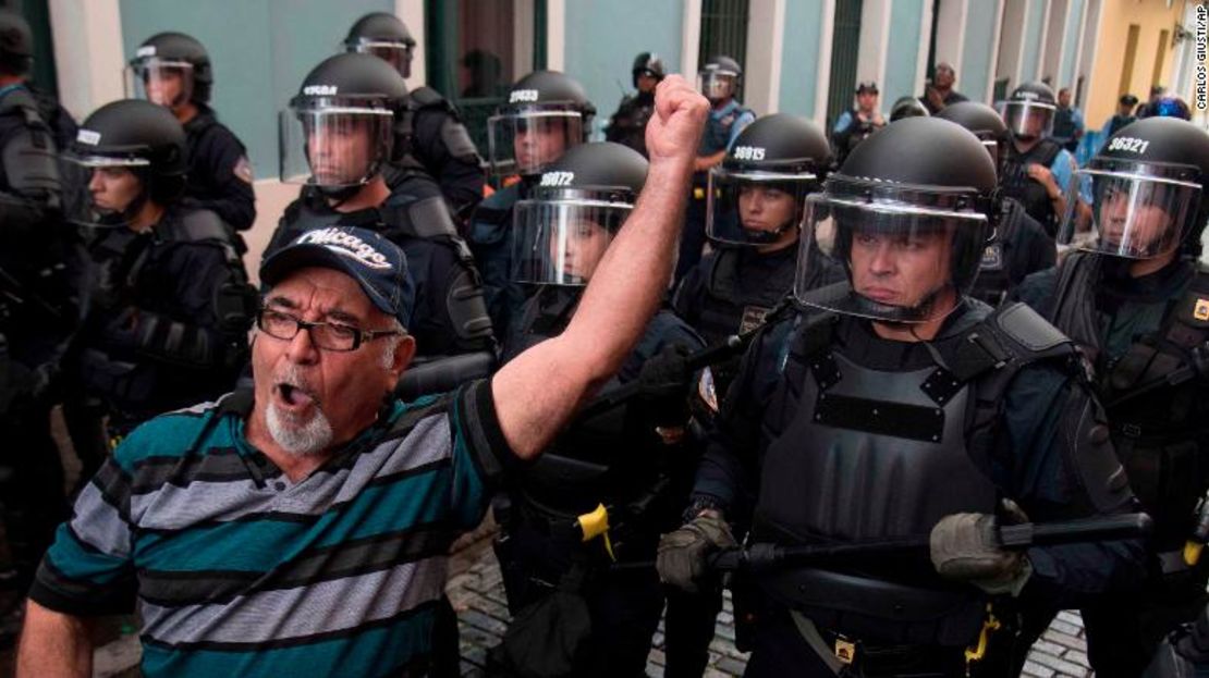 La policía bloquea el paso de manifestantes a la residencia del gobernador La Fortaleza en San Juan el domingo.