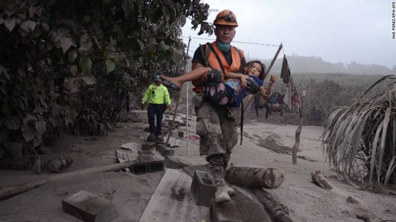 Un rescatista guatemalteco cargaa una niña en la zona de El Rodeo este 3 de junio tras la explosión.