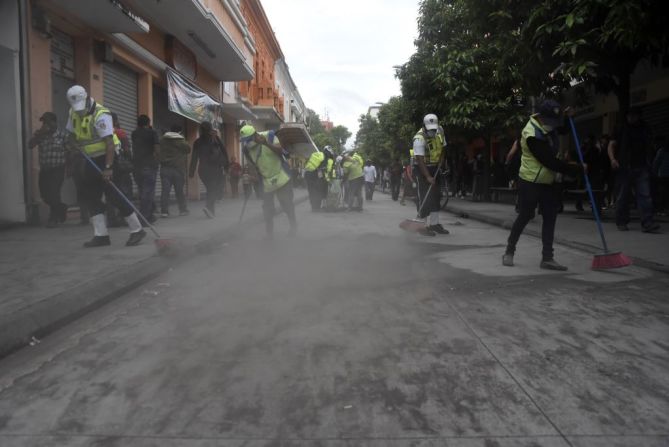 Empleados municipales barren las calles llenas de cenizas tras la erupción del Volcán de Fuego en Guatemala.