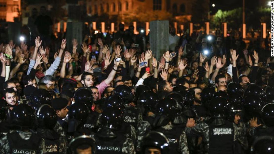 Manifestantes jordanos levantan las manos en protestas frente a la oficina del primer ministro.