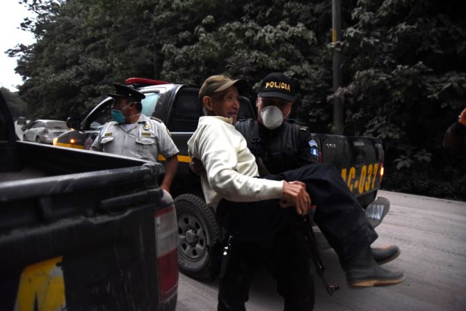 Un policía lleva a un anciano en brazos durante la evacuación.