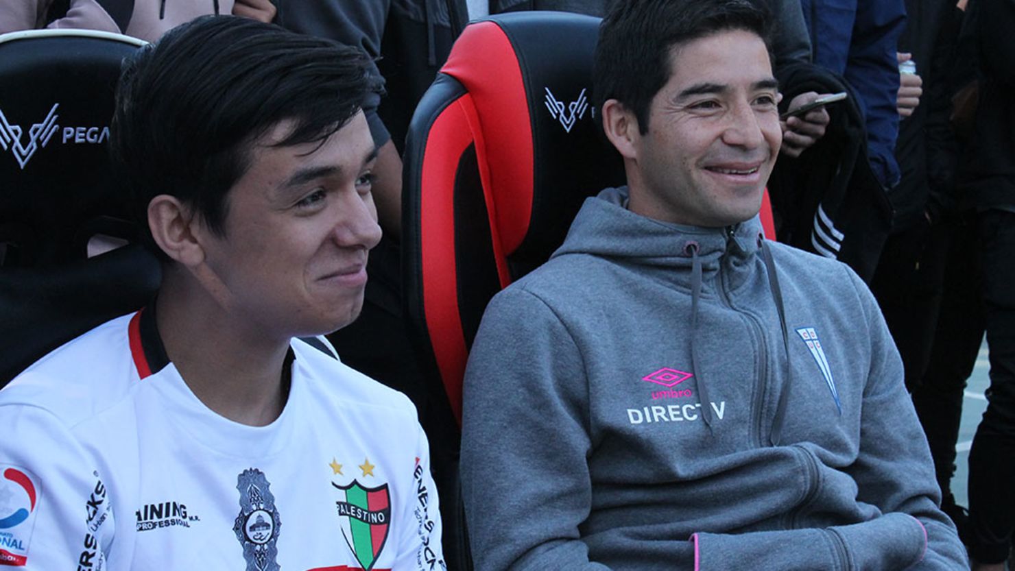 Foto del partido de exhibición de la LEF CHile. En la imagen, el gamer Matías Pino y el futbolista profesional Cristián Álvarez.