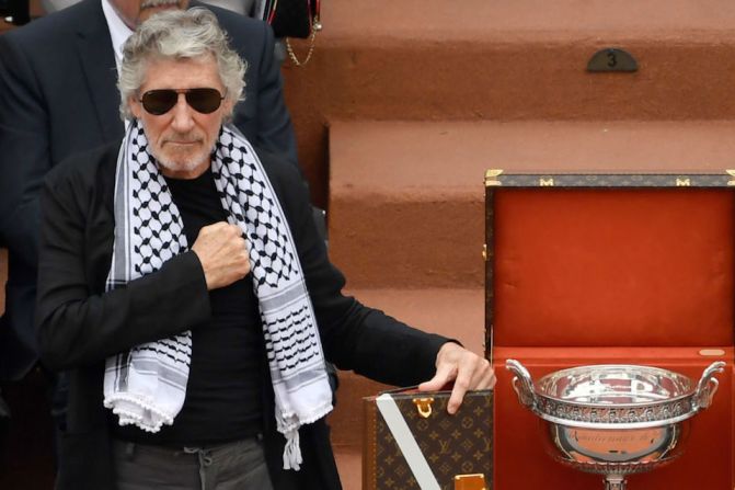 El músico británico Roger Waters, vistiendo un tradicional pañuelo palestino, junto a la copa que se entrega al ganador del torneo.