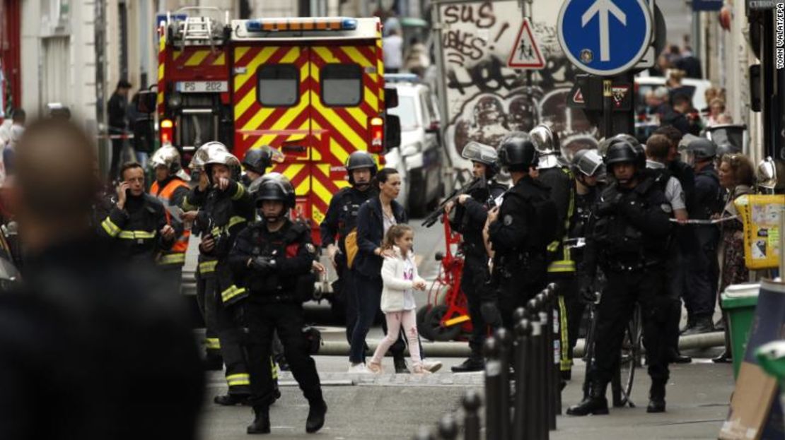 Una mujer y una niña son evacuadas por la policía el martes durante una situación de rehenes en París.