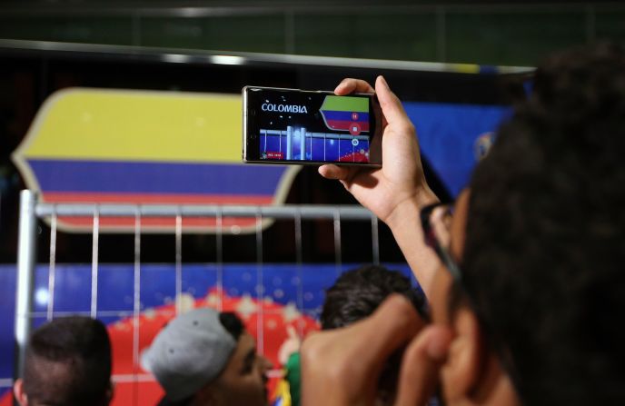 Un seguidor de Colombia toma una foto mientras el autobús del equipo con el equipo nacional de fútbol se prepara para abandonar el aeropuerto de Kazán. Colombia jugará en el grupo H.