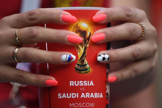 En el estadio, una fanática lleva la bandera de Rusia en sus uñas mientras sostiene un vaso oficial del partido de Rusia vs. Arabia Saudita.