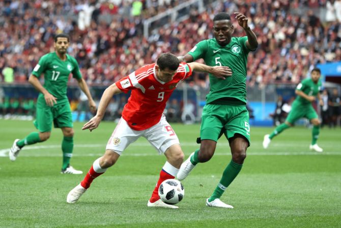 Rusia espera conquistar el título en casa empezando con Arabia Saudita. El grupo A está conformado además por Egipto y Uruguay. En esta foto aparecen Alan Dzagoev de Rusia y Omar Othman de Arabia Saudita.