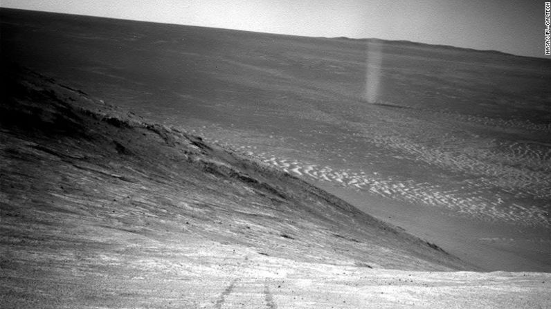 Desde una ubicación elevada, el Opportunity registró esta imagen de un remolino de polvo marciano a través del valle. Al igual que en la Tierra, un remolino es creado por una columna ascendente y giratoria de aire caliente. Cuando la columna gira lo suficientemente rápido, recoge pequeños granos de polvo del suelo, haciéndolo visible.