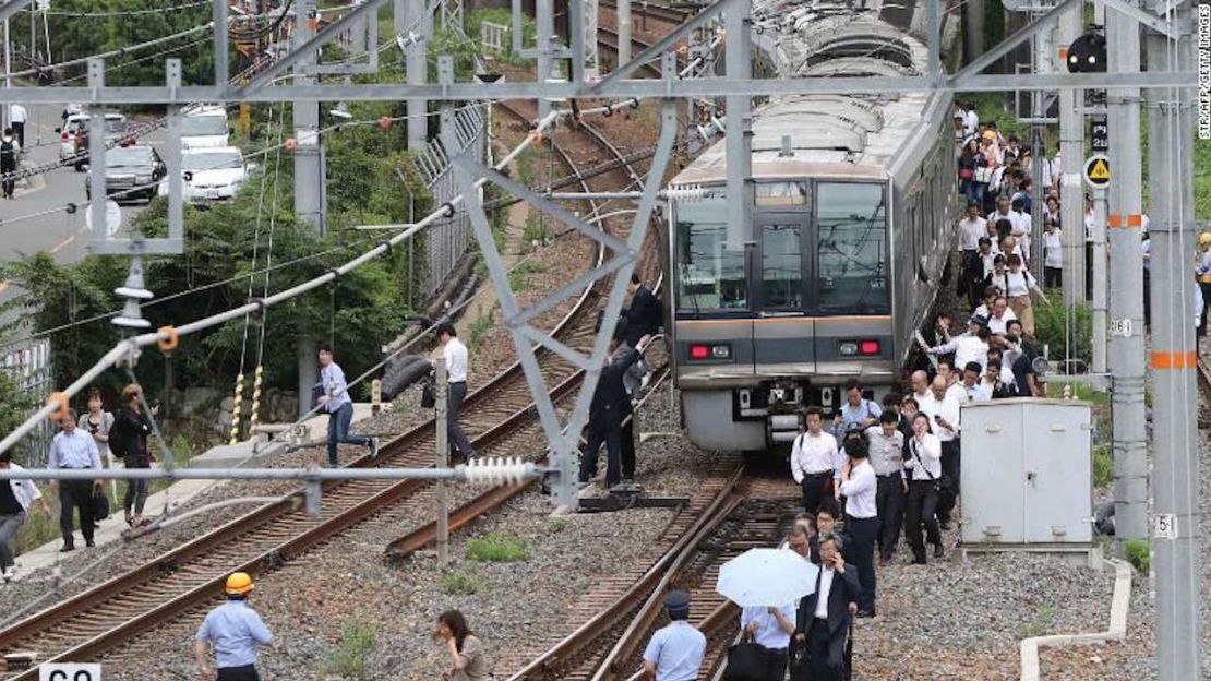 Un grupo de personas camina junto a las vías del tren tras el terremoto.