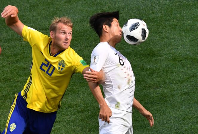 El defensor de Corea del Sur Park Joo-ho controla el balón junto al sueco Ola Toivonen.