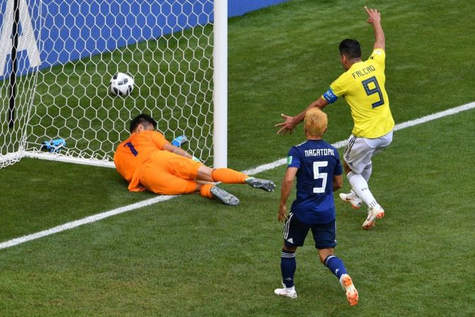 El arquero de Japón Eiji Kawashima agarra el balón en su portería luego de que el mediocampista de Colombia' Juan Quintero (fuera de cuadro) anotara.