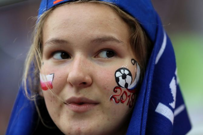 Una hincha pintada con la bandera de Polonia ve el partido desde la tribuna.