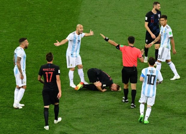 El centrocampista Ivan Rakitic (al centro) cae al piso después de una entrada del centrocampista argentino Javier Mascherano.