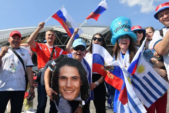 Fanáticos rusos y uruguayos apoyan a sus equipos a las afueras del Samara Arena. Uno de ellos lleva una imagen del delantero Edison Cavani, una de las estrellas de Uruguay en este partido.