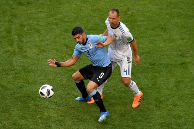 Luis Suárez disputa el balón contra el ruso Sergey Ignashevich.